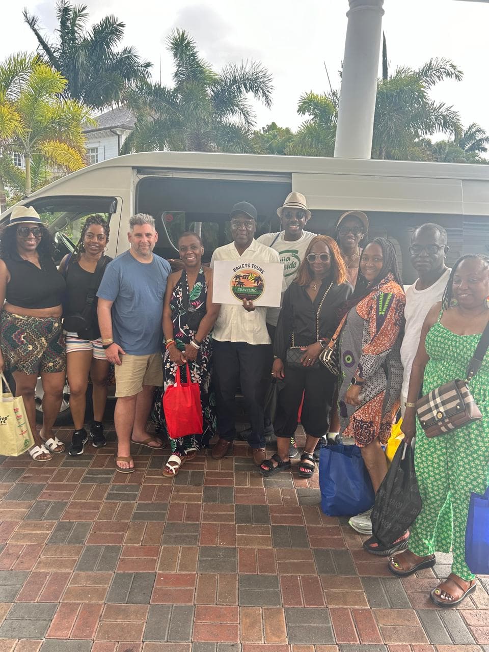 Mr. Bailey with a large group of guests beside the Baileys Tours van